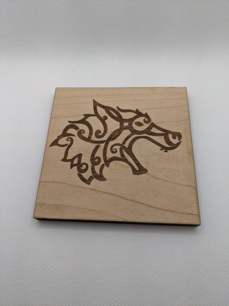 Wood coaster with inlaid wolf design