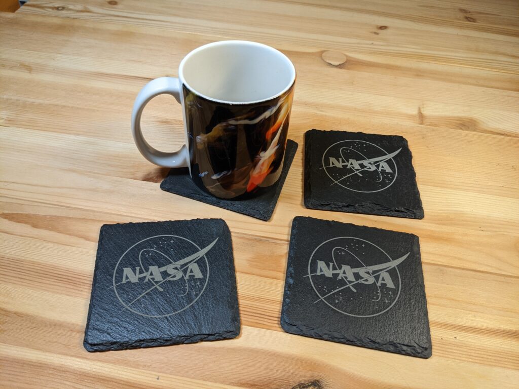 4 laser-engraved slate coasters with the NASA logo